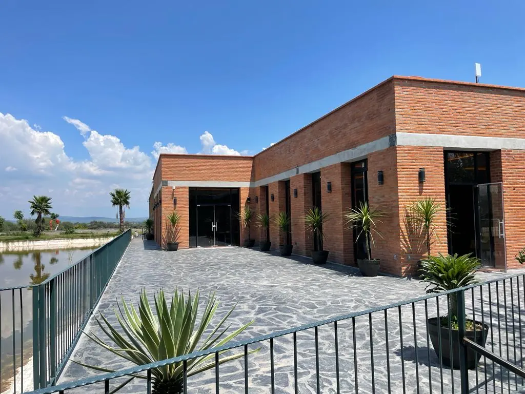 Vinícola El Secreto: edificio de ladrillo junto al lago